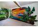 A vibrant mural with sunset and tropical foliage adds a colorful artistic touch to this outdoor area at 19531 Gulf Blvd # 306, Indian Shores, FL 33785