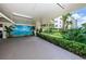 Parking garage with tropical mural and lush landscaping, creating a welcoming entrance to the building at 19531 Gulf Blvd # 306, Indian Shores, FL 33785