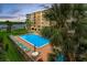 Beautiful outdoor pool area with palm trees, ideal for relaxing by the water and enjoying the sunset at 19531 Gulf Blvd # 306, Indian Shores, FL 33785