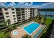 Aerial view of community pool, well-kept lawn, and waterfront access for a relaxing living experience at 19531 Gulf Blvd # 306, Indian Shores, FL 33785