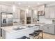 A modern kitchen with gray cabinets, stainless steel appliances, an island with seating, and pendant lighting at 1959 Longliner Loop, Wesley Chapel, FL 33543