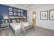 Stylish primary bedroom with a decorative wall, a king-sized bed, and an ensuite bathroom at 1959 Longliner Loop, Wesley Chapel, FL 33543