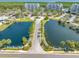 Aerial view of condo buildings with dual ponds featuring palm trees and manicured landscape at 2333 Feather Sound Dr # A107, Clearwater, FL 33762