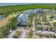 Aerial view of multi-story condo buildings with golf course, landscaping and parking areas overlooking bay waters at 2333 Feather Sound Dr # A107, Clearwater, FL 33762
