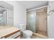 Bathroom featuring a tiled shower with glass door, vanity, and toilet at 2333 Feather Sound Dr # A107, Clearwater, FL 33762