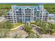 Exterior daytime view of condo building featuring covered entryway, palm trees and landscaping at 2333 Feather Sound Dr # A107, Clearwater, FL 33762