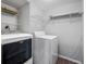 Laundry room features washer and dryer with shelving for storage and vinyl flooring at 2333 Feather Sound Dr # A107, Clearwater, FL 33762