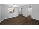 Open living area with dark wood-look floors and view of the kitchen and doorway at 2333 Feather Sound Dr # A107, Clearwater, FL 33762