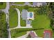 Aerial view of estate showcasing pool, tennis court, circular driveway, lush landscaping, and sprawling grounds at 2395 Campbell Rd, Clearwater, FL 33765