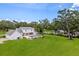 Expansive backyard featuring a swimming pool, lush greenery, and a covered patio perfect for outdoor entertaining at 2395 Campbell Rd, Clearwater, FL 33765