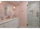 Elegant bathroom with a marble vanity, a glass-enclosed shower, and pink floral wallpaper for a classic look at 2395 Campbell Rd, Clearwater, FL 33765