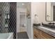 Modern bathroom with black-and-white tiled shower, granite countertop, and sleek fixtures for a sophisticated look at 2395 Campbell Rd, Clearwater, FL 33765
