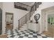 Elegant entryway with a modern staircase, black and white checkered floor, and stylish decor accents at 2395 Campbell Rd, Clearwater, FL 33765
