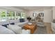 Bright living room with sliding doors to pool, with wood coffee table, and view to the kitchen at 2395 Campbell Rd, Clearwater, FL 33765
