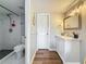 Bright bathroom featuring updated vanity, framed mirror, modern lighting fixtures, toilet, and a tiled walk-in shower at 2400 Winding Creek Blvd # 14-201, Clearwater, FL 33761