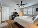 Bedroom featuring wood floors, a ceiling fan, and a window with blinds and curtains at 2400 Winding Creek Blvd # 14-201, Clearwater, FL 33761