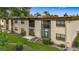 Exterior view of a multi-unit building featuring well-maintained lawns and landscaping at 2400 Winding Creek Blvd # 14-201, Clearwater, FL 33761