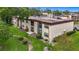 Exterior view of a multi-unit property with manicured lawn and walkways at 2400 Winding Creek Blvd # 14-201, Clearwater, FL 33761