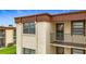 Beige two-story condo with a brown accent trim, window and balcony at 2400 Winding Creek Blvd # 14-201, Clearwater, FL 33761