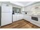 Bright kitchen with white appliances, cabinets, and a breakfast bar pass-through at 2400 Winding Creek Blvd # 14-201, Clearwater, FL 33761