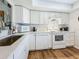 A modern kitchen featuring white appliances, cabinetry, countertop, and hardwood flooring at 2400 Winding Creek Blvd # 14-201, Clearwater, FL 33761