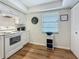 Modern kitchen featuring white appliances, cabinetry, and hardwood flooring at 2400 Winding Creek Blvd # 14-201, Clearwater, FL 33761