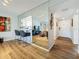 Spacious living room with a mirrored wall section, a breakfast bar, and hardwood floors at 2400 Winding Creek Blvd # 14-201, Clearwater, FL 33761