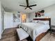 Main bedroom featuring wood floors, ceiling fan, and accent wall art at 2400 Winding Creek Blvd # 14-201, Clearwater, FL 33761