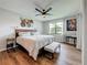 Main bedroom featuring ceiling fan, wood floors, and view to large window at 2400 Winding Creek Blvd # 14-201, Clearwater, FL 33761