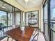 Enclosed patio features a dark wood table with views of the adjacent bedroom with ceiling fan and sliding glass doors at 2400 Winding Creek Blvd # 14-201, Clearwater, FL 33761