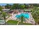 Aerial view showcasing community pool with lounge seating, well-maintained landscaping, and shade structure at 2400 Winding Creek Blvd # 14-201, Clearwater, FL 33761