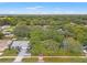 An aerial view showcases the property's surroundings with mature trees and neighborhood charm at 2418 Deltona Blvd, Spring Hill, FL 34606