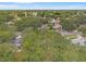 A beautiful aerial view of the neighborhood featuring lush trees and a clear blue sky at 2418 Deltona Blvd, Spring Hill, FL 34606