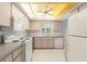 Bright kitchen with modern appliances, white cabinets, and a unique ceiling design with fan and natural light at 2418 Deltona Blvd, Spring Hill, FL 34606