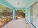 View of the screened porch with a large sliding glass door and views of the foliage at 2418 Deltona Blvd, Spring Hill, FL 34606