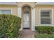 Inviting front entrance featuring a glass-paneled door, arched entryway, and manicured hedges at 2616 Tottenham Dr, New Port Richey, FL 34655