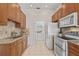 Bright kitchen with granite countertops, stainless steel appliances, and a washer/dryer utility closet at 2616 Tottenham Dr, New Port Richey, FL 34655