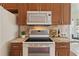 The kitchen has a flat top oven with microwave above, wine glasses, and granite countertops at 2616 Tottenham Dr, New Port Richey, FL 34655