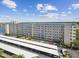 Wide aerial shot of a condominium and parking, showcasing lush surroundings against a partly cloudy, blue sky backdrop at 2960 59Th S St # 303, Gulfport, FL 33707