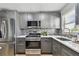 Modern kitchen featuring stainless steel appliances, gray cabinets, and a stylish backsplash at 2960 59Th S St # 303, Gulfport, FL 33707