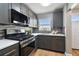 Well-lit kitchen featuring gray cabinets, stainless steel appliances, and modern backsplash at 2960 59Th S St # 303, Gulfport, FL 33707