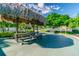 Thatched-roof picnic area with outdoor cooking space and picnic table on a sunny day at 2960 59Th S St # 303, Gulfport, FL 33707