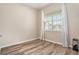 Bright bedroom featuring wood-look floors, a window, and neutral paint at 30753 Pumpkin Ridge Dr, Wesley Chapel, FL 33543