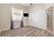 Bright bedroom featuring wood-look floors, large window, TV, and a closet at 30753 Pumpkin Ridge Dr, Wesley Chapel, FL 33543