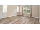 Bright bedroom featuring wood floors, neutral walls, and large windows with sheer curtains at 30753 Pumpkin Ridge Dr, Wesley Chapel, FL 33543