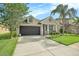 Well-kept single-Gathering home features a green lawn, a two-car garage, and a cozy front porch area at 30753 Pumpkin Ridge Dr, Wesley Chapel, FL 33543