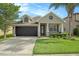 Charming single-story home showcasing a well-maintained lawn, a two-car garage and a welcoming front porch at 30753 Pumpkin Ridge Dr, Wesley Chapel, FL 33543