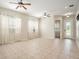 Spacious living area featuring neutral tile flooring, large windows with curtains, and ceiling fans at 30753 Pumpkin Ridge Dr, Wesley Chapel, FL 33543