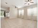 Bright living room showcasing tile floors, three windows with curtains, and multiple ceiling fans at 30753 Pumpkin Ridge Dr, Wesley Chapel, FL 33543