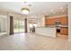 Bright living area showcasing tile flooring, a casual dining area, and a kitchen with wooden cabinets at 30753 Pumpkin Ridge Dr, Wesley Chapel, FL 33543